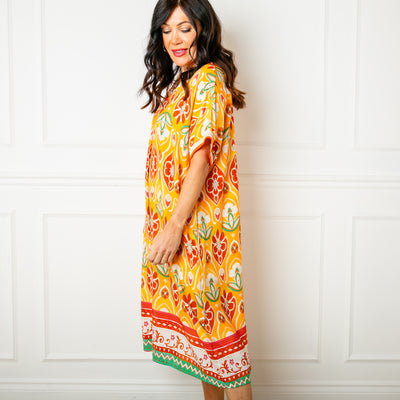 The mandarin orange Lotus Flower Sun Dress featuring a beautiful colourful floral pattern